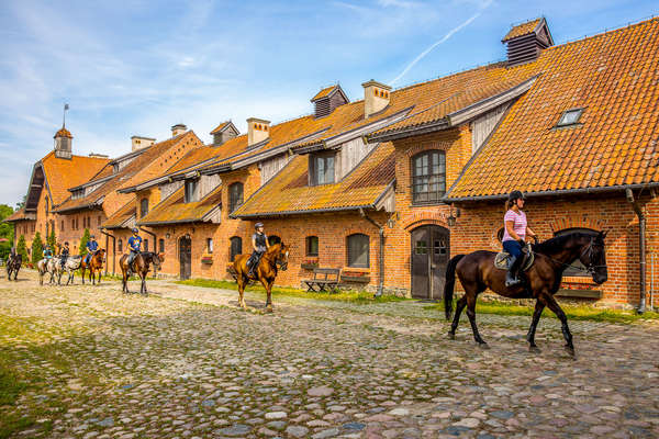 Cavaliers au pas le long du Palais Galiny en Pologne