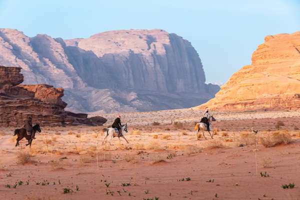 Trois cavaliers au galop dans le wadi rum